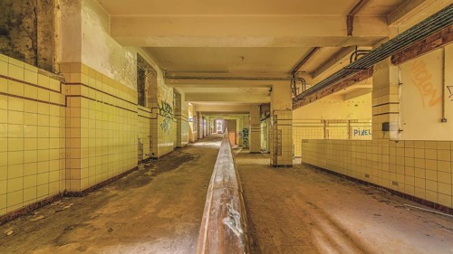 Long abandoned corridor with tiled walls and graffiti, industrial decay, Preventorium Dolhain, Lost