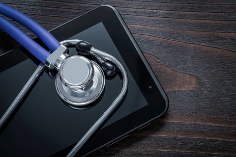 Close up of stethoscope and pad on vintage wooden background medicine concept