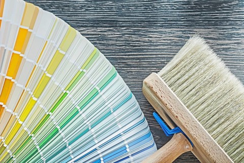 Horizontal view of color palette fan paintbrush on wooden board
