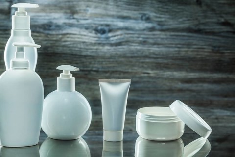 Higiene products white plasic pump dispensers tube and jar cream on vintage wooden background