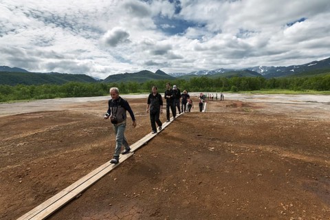 NALYCHEVO, KAMCHATKA, RUSSIA, JULY 30, 2014: Tourists walk on wooden deck, overlooking Thermal Pad