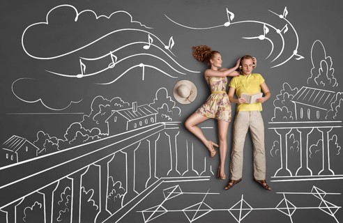 Love story concept of a romantic couple with different interests on holiday against chalk drawings