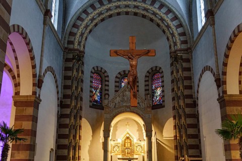 Romanesque church interior with wooden cross, colourful windows and pastoral atmosphere, ankum,