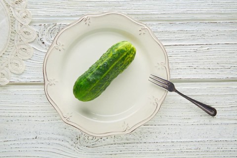 Cucumber full in white plate minimalist concept of raw vegetarian food