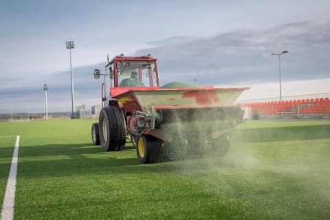 Pouring infill granules in to a football pitch with artificial grass in Lubin, Poland, Europe