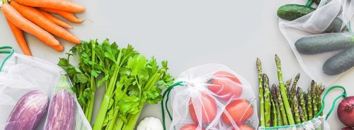 Fresh organic vegetables in eco reusable produce shopping bags flat lay, top view with copy space