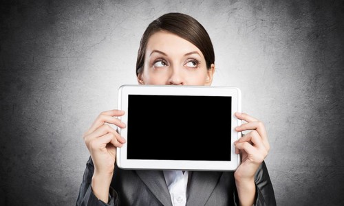 Businesswoman holding tablet computer with blank screen. Beautiful woman in business suit show