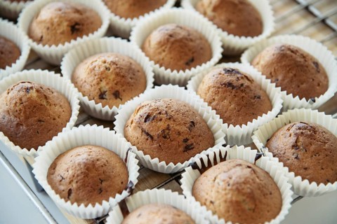 Homemade Muffins with Chocolate Chips on a Oven Grill over a Wooden Table, in a shallow depth of