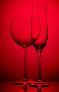 Two empty wineglasses on a red background