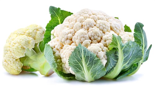 Fresh whole and partial cauliflower with green leaves isolated on a white background in high