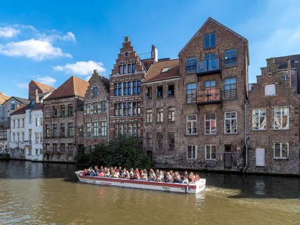 Tourists in the tourist boat for the canal cruise on the river Leie and in the background together
