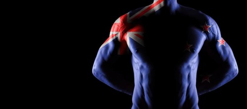 New Zealand flag on muscled male torso with abs, black background