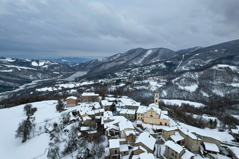 Aerial view of vezzolacca, a small village in the ligurian apennines, covered by snow in winter