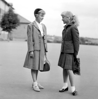 Girls in the 1950s. Two teenage girls dressed in outfits typical of the decade. Typical schoolgirls