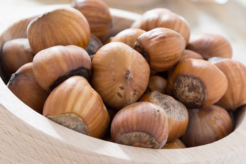 Hazelnuts in wooden bowl ready to be cracked and eaten