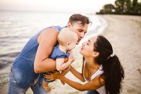 A young, beautiful family of three. Mum, Dad and daughter in the arms of my father play, rejoice,
