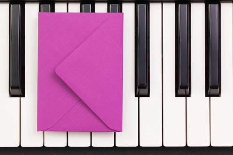 Funny arrangement envelope on the piano keybords - Flat lay image