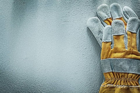 Pair of protective gloves on concrete background copy space