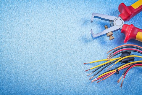 Insulated wire strippers electrical cables on blue background copy space electricity concept