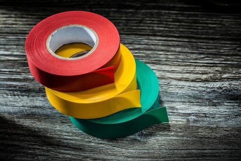 Rolled electricians tapes on wooden board