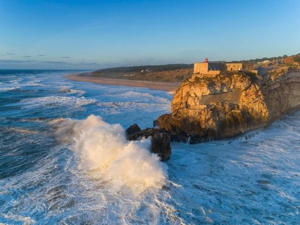 Aerial view of lighthouse on a cliff with a fortress on the coast of the Atlantic ocean with big