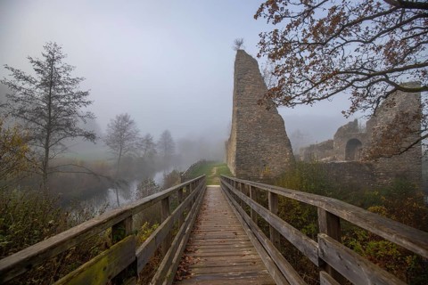 Ruins of a castle. Landscape shot in autumn. Defence system in a lake. Foggy landscape in the