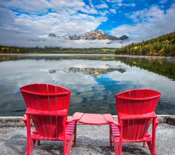 Two red sun loungers are on the Pyramid Lake. Concept of vacation and tourism
