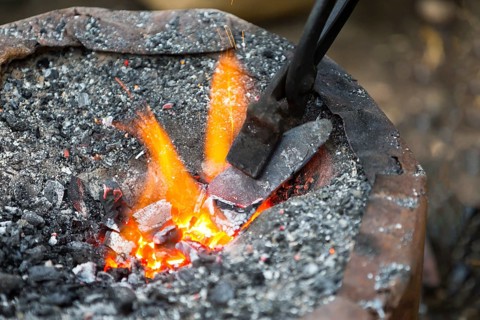Hot metal arrow blade in the fire before being hammered by a blacksmith