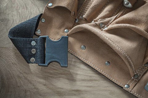 Leather construction belt on wooden board