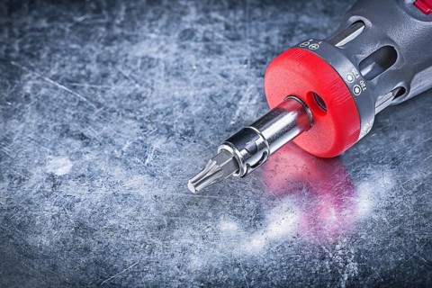 Threaded screwdriver on metallic background close up view construction concept