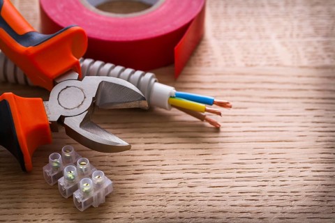 Nippers insulating tape and terminal blocks for electric cables on wooden board