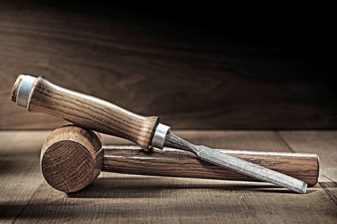 Chisel and small wooden malet on vintge wood