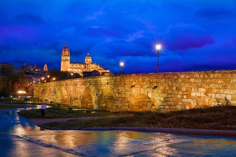 Salamanca skyline sunset and roman bridge over Tormes river in Spain