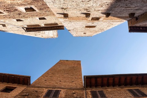 In the streets of San Gimignano, view on the towers Pettini and Salvucci, Italy, Europe
