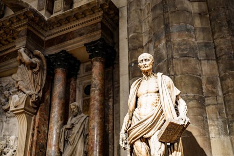 Statue of Saint Bartholomew with a book in his hands in the Duomo. Italy, Milan.
