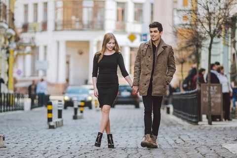 Urban modern young love couple walking romantic talking talking, holding hands on a date. Young