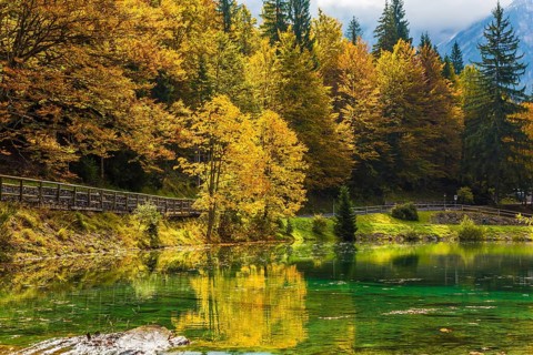 Fantastically beautiful autumn forests are reflected in the water. The quiet lake in Northern