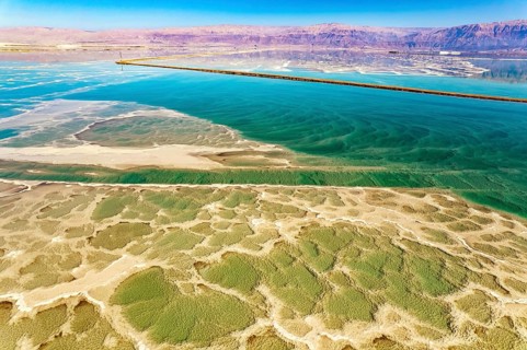 Salt deposits are visible on the seabed. Magic of the Dead Sea. The clear green water of the salty