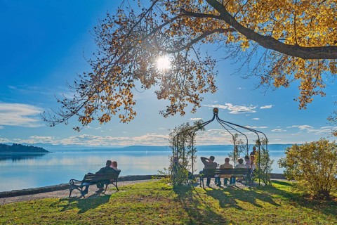 Park benches with visitors in the autumnal spa gardens, Herrsching am Lake Ammer, Upper Bavaria,