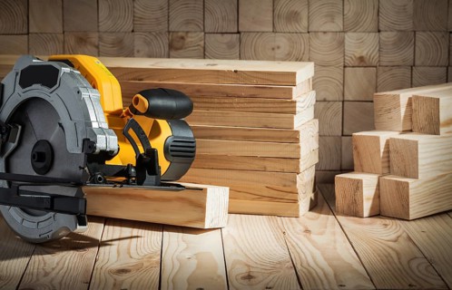 Electric power tool corded circular hand saw on wooden background