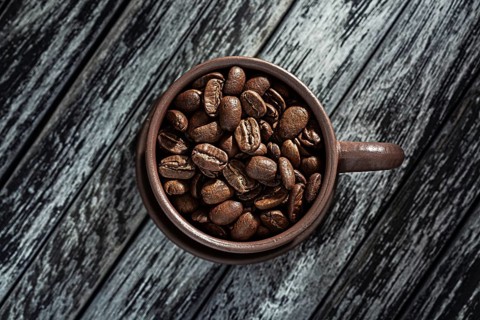 Roasted Coffee Beans In Cup On Wooden Background