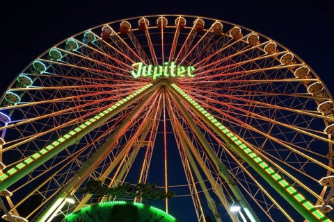 Ferris wheel illuminated at night, perspective, bright lights, many colours, funfair in Bad