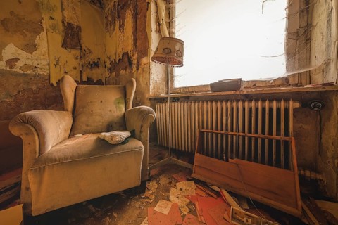 An outdated room with armchair and lamp next to a neglected heating system, Lost Place, Urologist's
