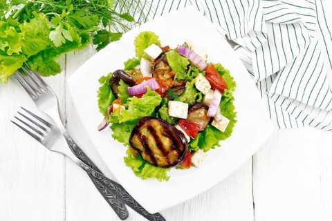 Salad of fried eggplant, fresh tomato with red onion and salted feta cheese, seasoned with