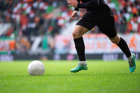 Soccer ball and legs of player during football match