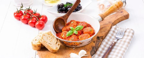 Baked mini meatballs in tomato sauce with basil