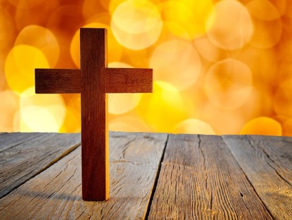 Christian wood cross on blur flare lights and wooden background