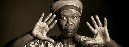 African man in traditional clothes toothy smile, on grey background