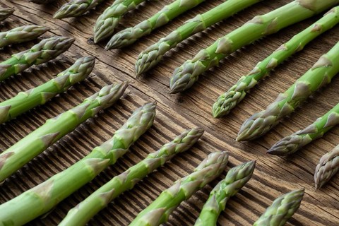 Fresh raw garden asparagus on rustic wooden table background