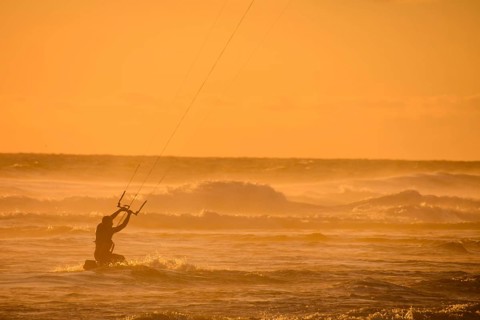 Single surfer at sunset on a calm ocean